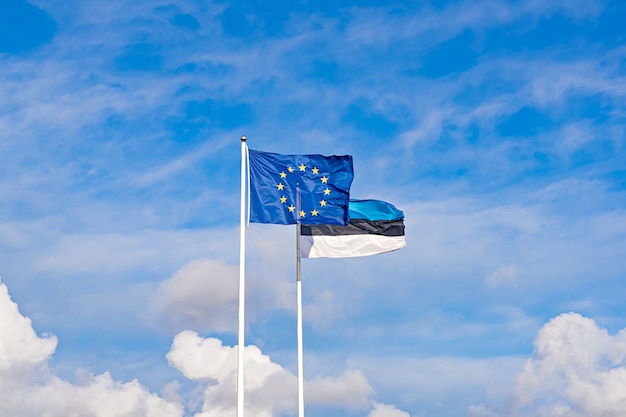 青い空を背景に欧州連合とエストニアの2つの手を振る旗。エストニア独立記念日は2月24日に祝われます