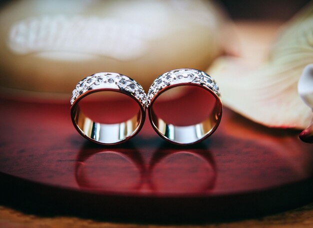 Two wedding rings are on a red tray with the word filigree on it.