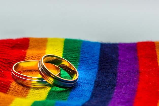 무지개의 패브릭 색상에 두 개의 결혼 반지. 개념 동성 결혼.