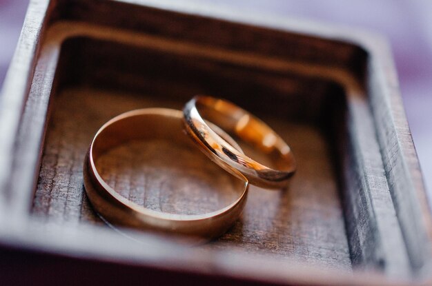 two wedding rings lie in a wooden box