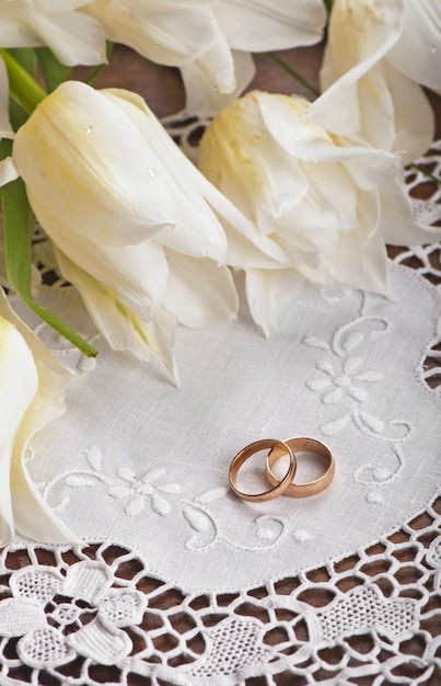 Two wedding rings and white tulips close up