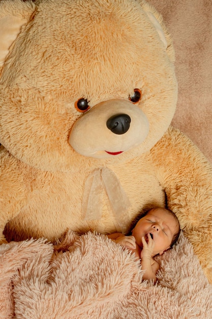 Two week old newborn baby sleeping on teddy bear