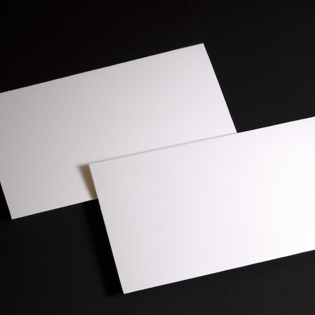 Two white business cards on a black background