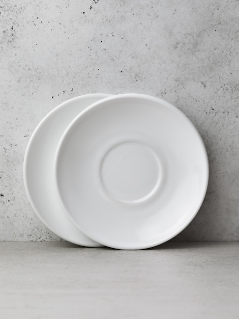 Two white ceramic saucers on the table