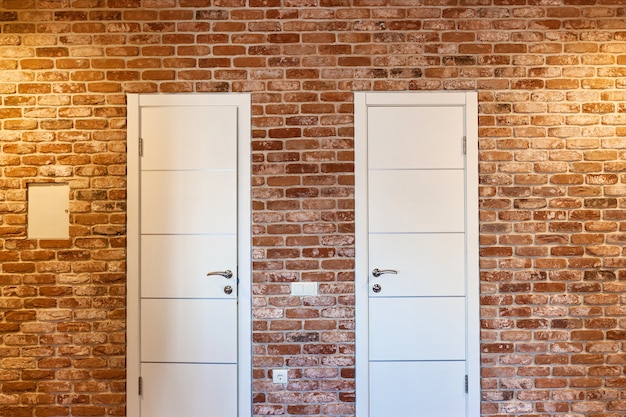 Two white doors in a brick wall. Two doors.