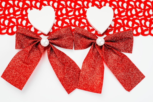 Two white hearts with red bows on a white background romantic Valentine s day concept