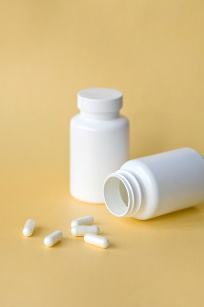 Two white jars with tablets on a yellow background medicines