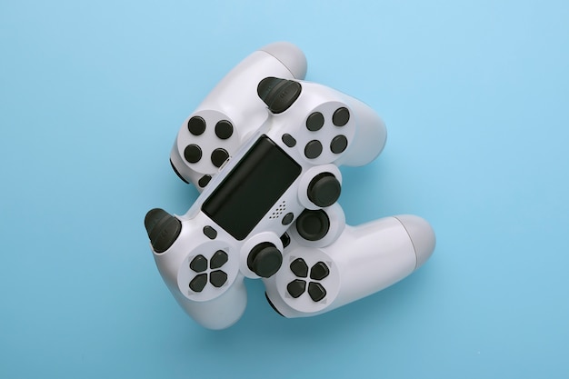 Photo two white joystick gamepad, game console on blue colourful trendy modern fashion pin-up background