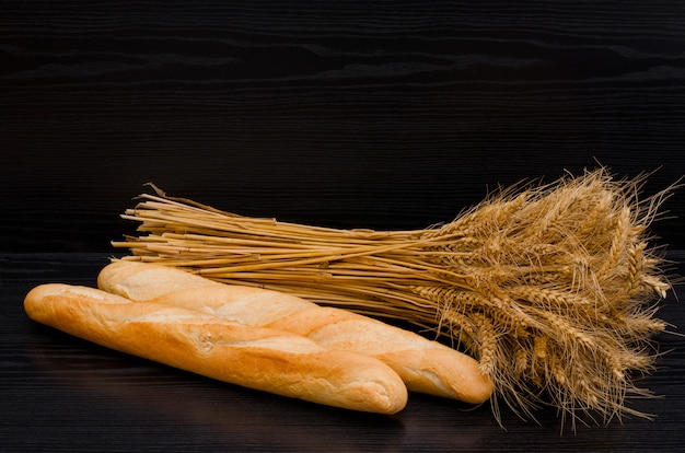 Two white loaf and a sheaf on a black background