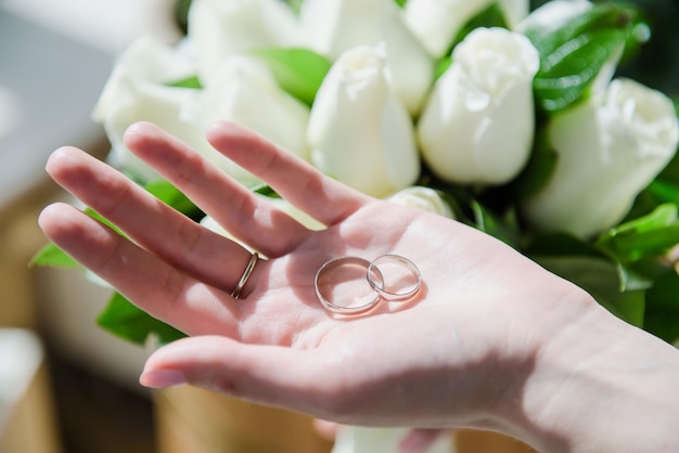 Foto due fedi nuziali bianche sulla mano delle spose