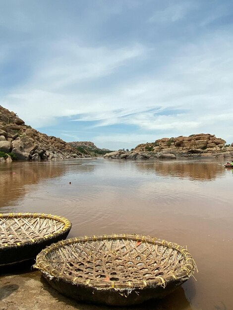 two wicker baskets are in the water with a sky background