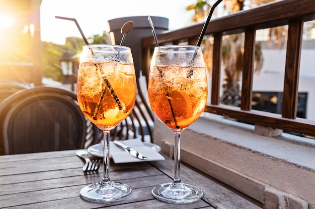 Two wine glass of cold cocktail Aperol spritz on table