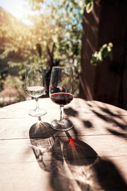 Two wine glasses on the vintage wooden table outside background