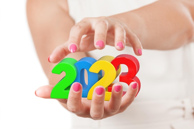 Two Woman Hands Protecting 2023 New Year Sign