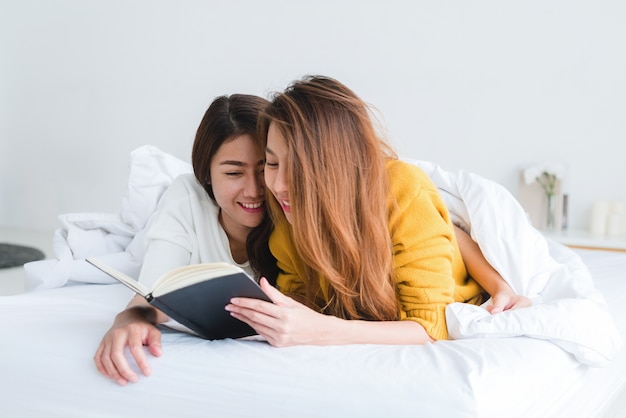 two woman reading a book on bed in the bedroom