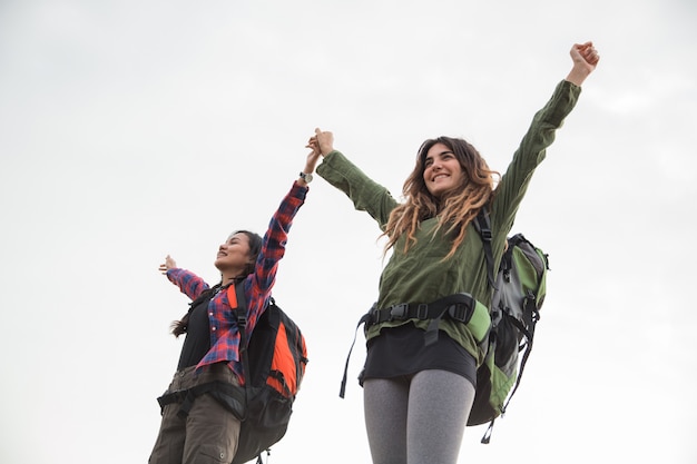 Two woman standing with raised arms