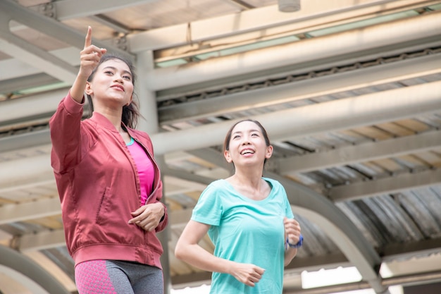 Two women are jogging in the city