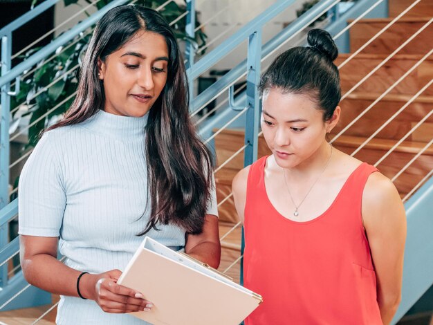 写真 2人の女性がその上にある言葉を書いた本を見ています