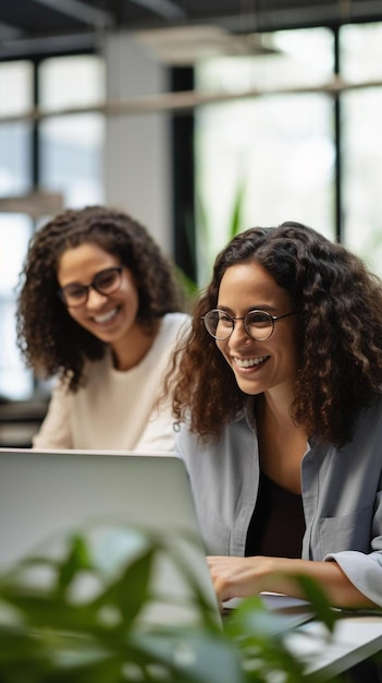 two women are looking at a laptop and smiling