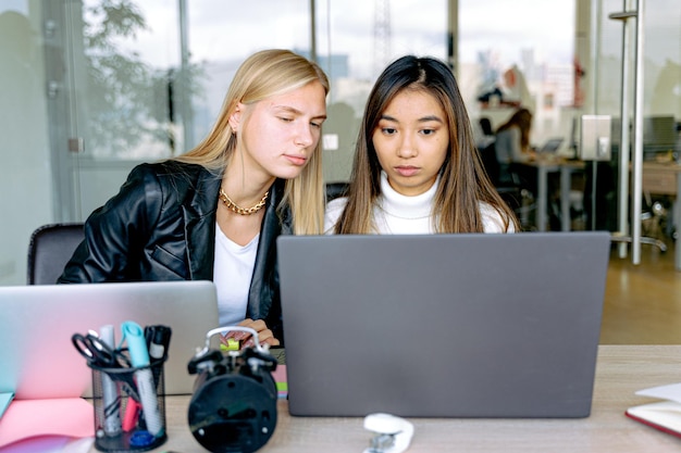 two women are looking at a laptop that has the word quot on it quot