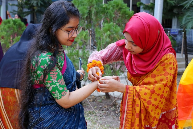 Two women are seen in a photo one of them is wearing a sari and the other is wearing a sari