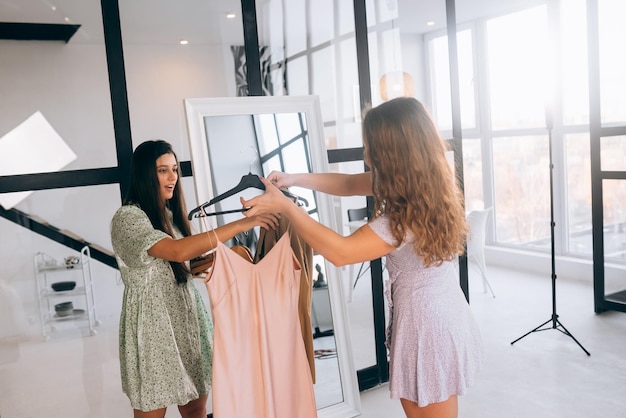 Two women choose and try on clothes at home