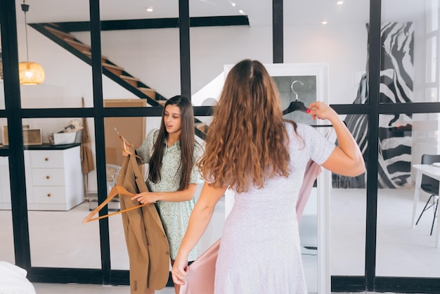 Two women choose and try on clothes at home