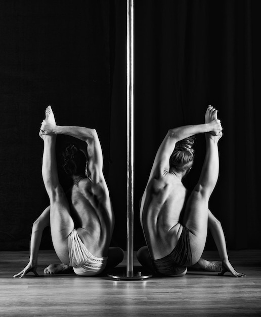 Two women dancing on pylon