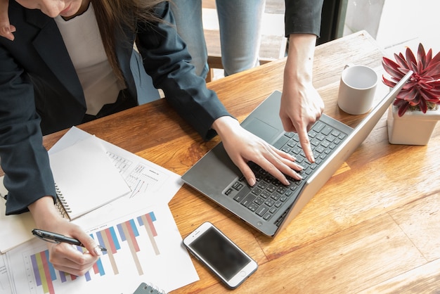 two women discuss job on labtop in coffee shop