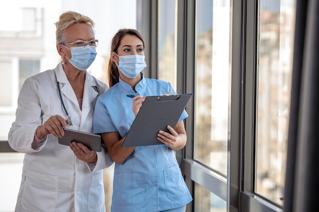 Two women doctors looking at tablet