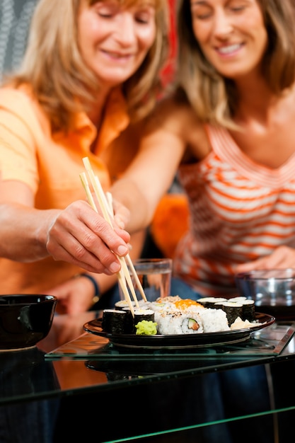 Two women eating sushi