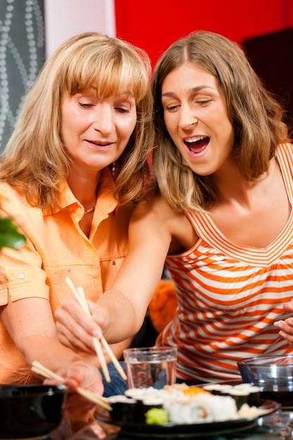 Two women eating sushi