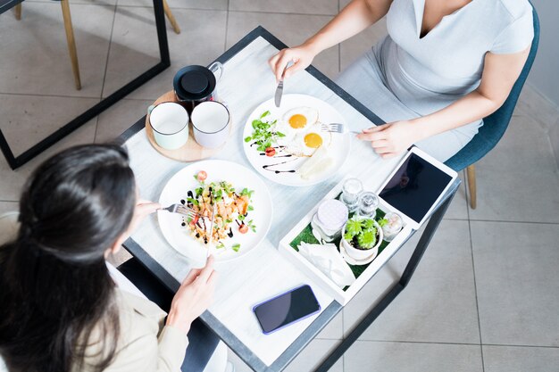 Two Women Enjoying Meal in Cafe