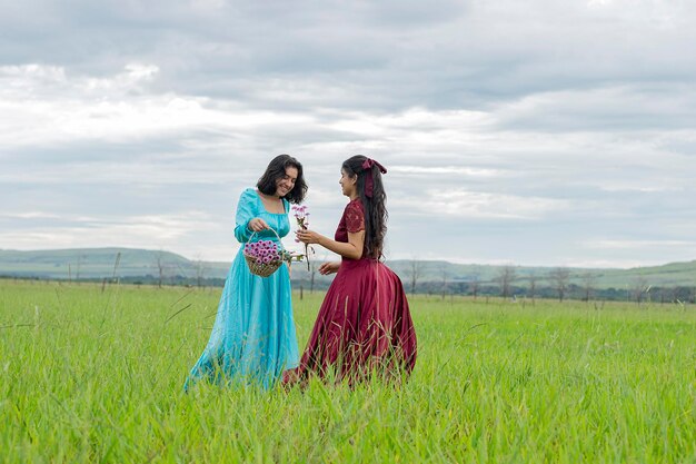 Photo two women in a field with a bouquet of flowers