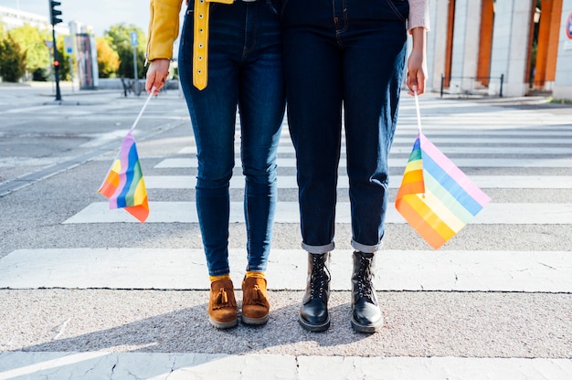 Two women friends hanging out in the city waving LGBT in Madrid city