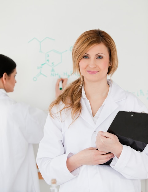 Two women in front of a white board