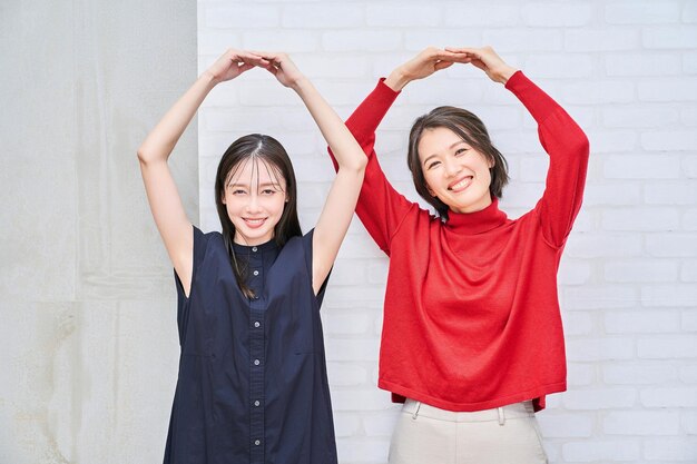 Two women giving an OK hand sign