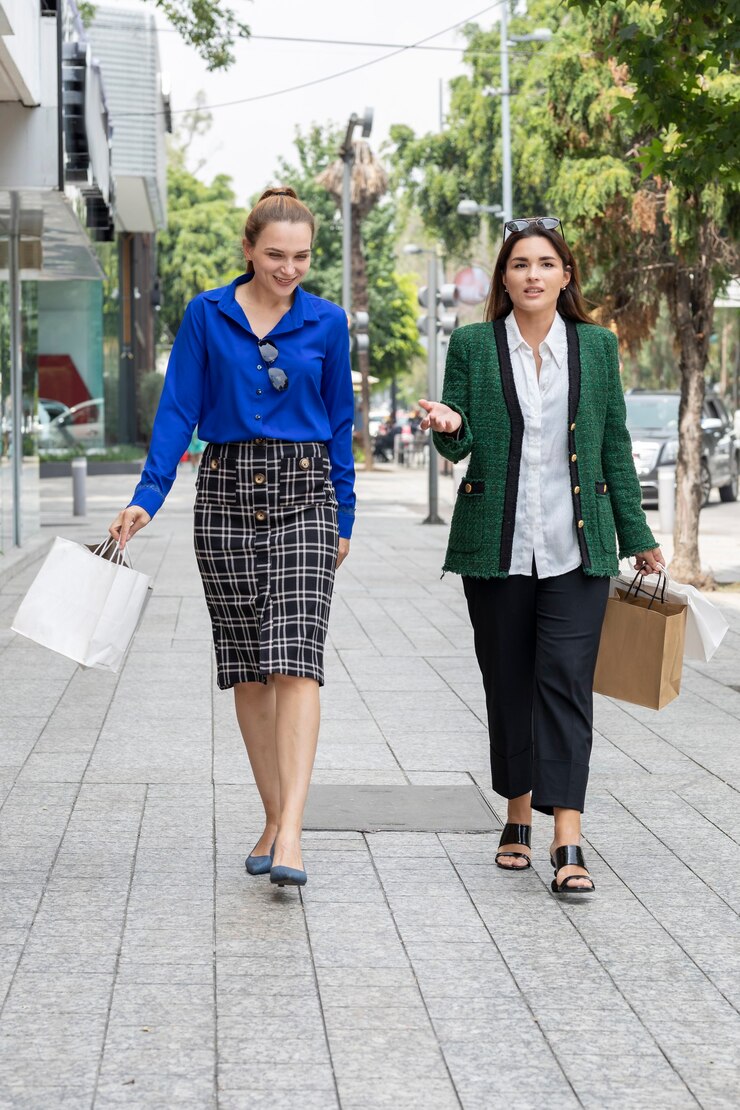 Two women happily walk through the city streets after shopping