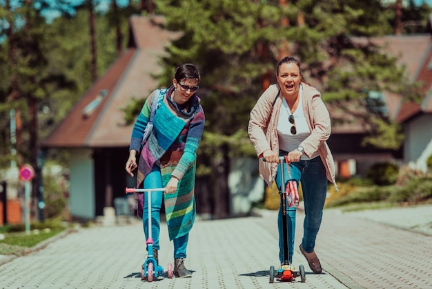 Two women having fun in the park while riding a scooter.