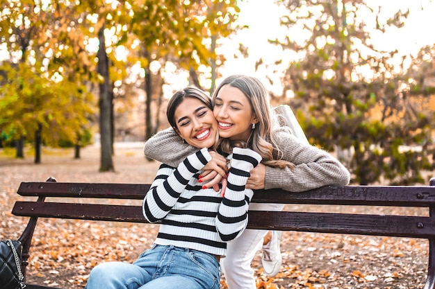 Two women hugging on a park bench