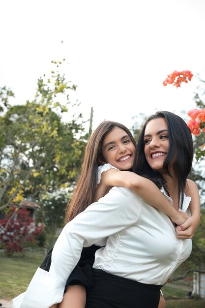 Photo two women hugging and smiling in a park