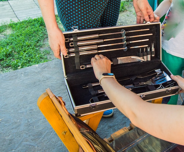 Two women look at a luxury barbecue set, in a gift box.