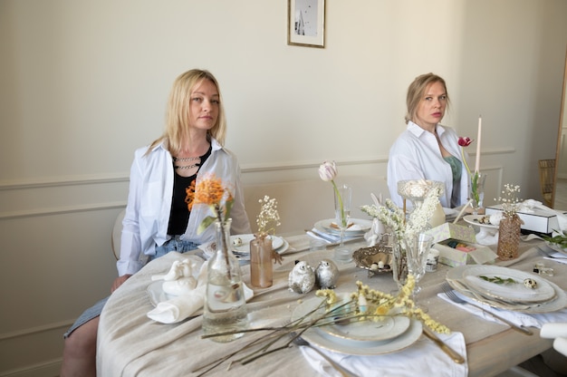 Two women near a beautiful table.