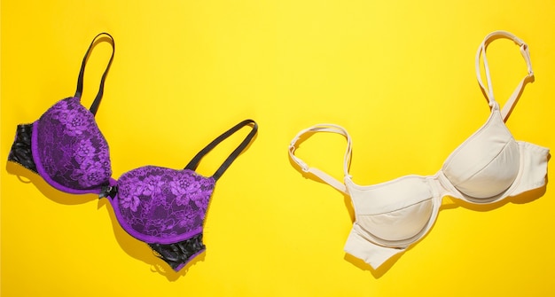 Two women's bras on yellow background. Top view