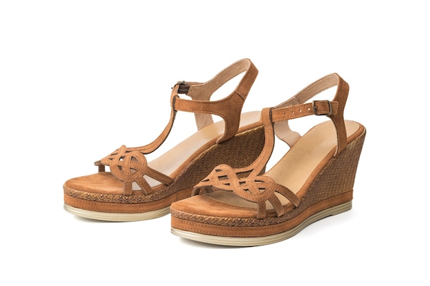 Two women's brown sandals isolated on a white background.