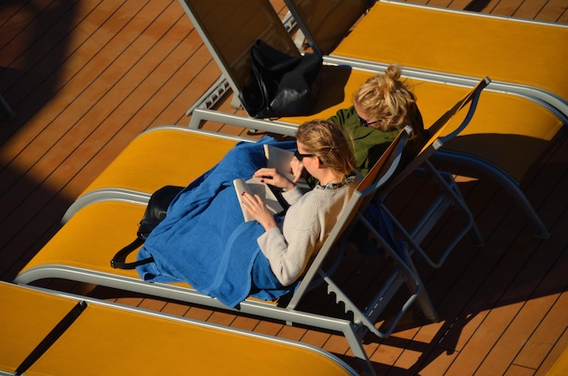 책을 읽고 있는 태양 아래 배에 있는 두 여자
