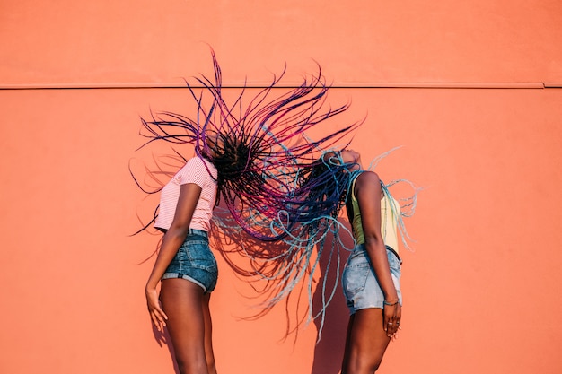 Two women sisters dancing moving hair outdoor