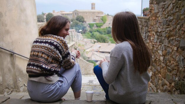 Two women sit by the stairs and talking