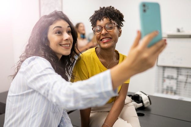 Foto due donne che si fanno selfie in ufficio