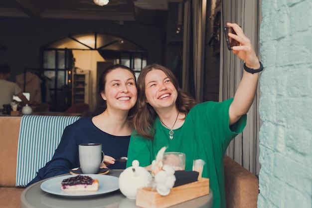 Two women talking and drinking coffee in cafe